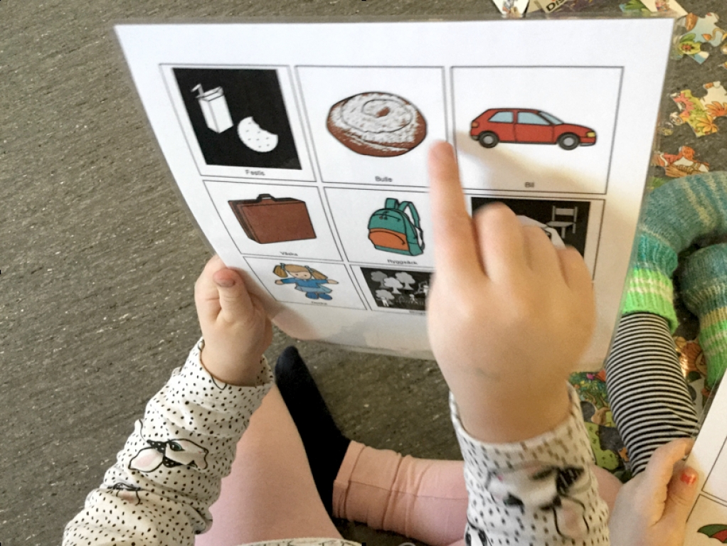 bildkarta och en barnhand som pekar på en bild